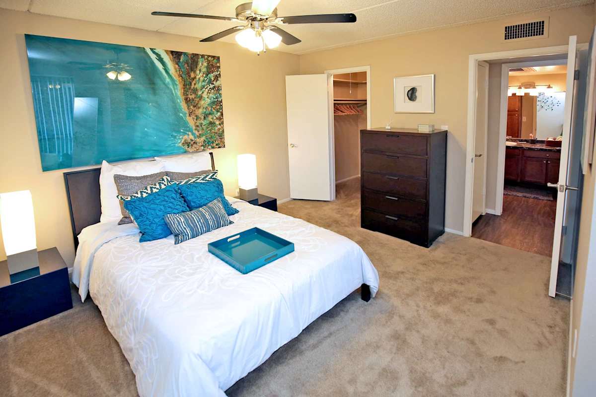 Furnished bedroom shown — representative home at Arcadia Villa Apartments.