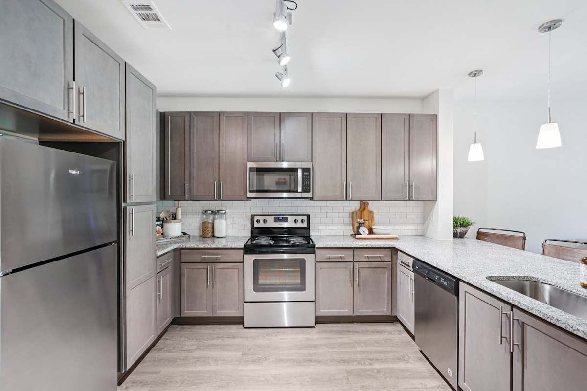 Granite kitchen with island and stainless appliances - The Kirkwood Apartments, Atlanta GA