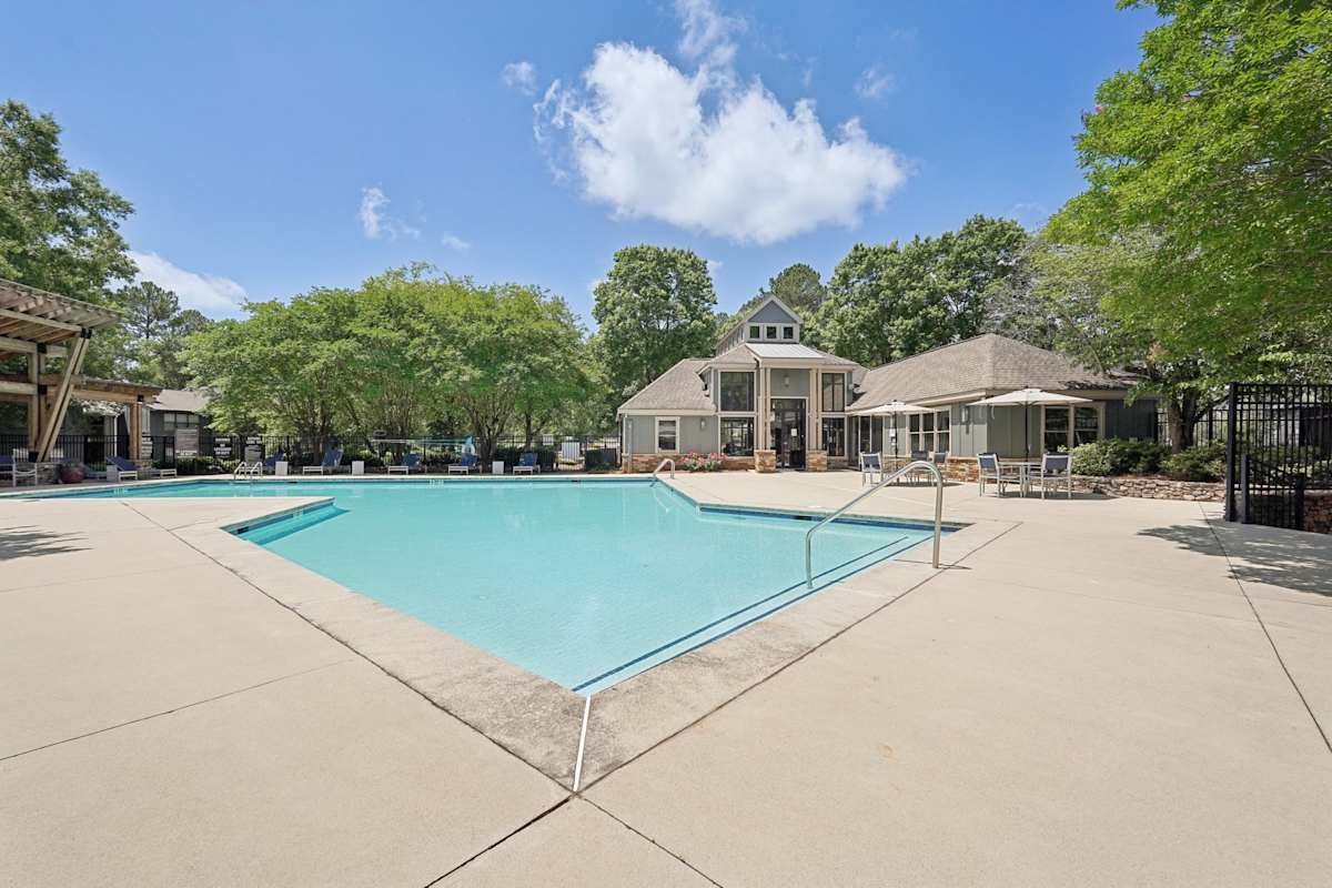 Wesley Trevento Apartments at Lithia Springs pool with lounge chairs and clubhouse - Lithia Springs, GA