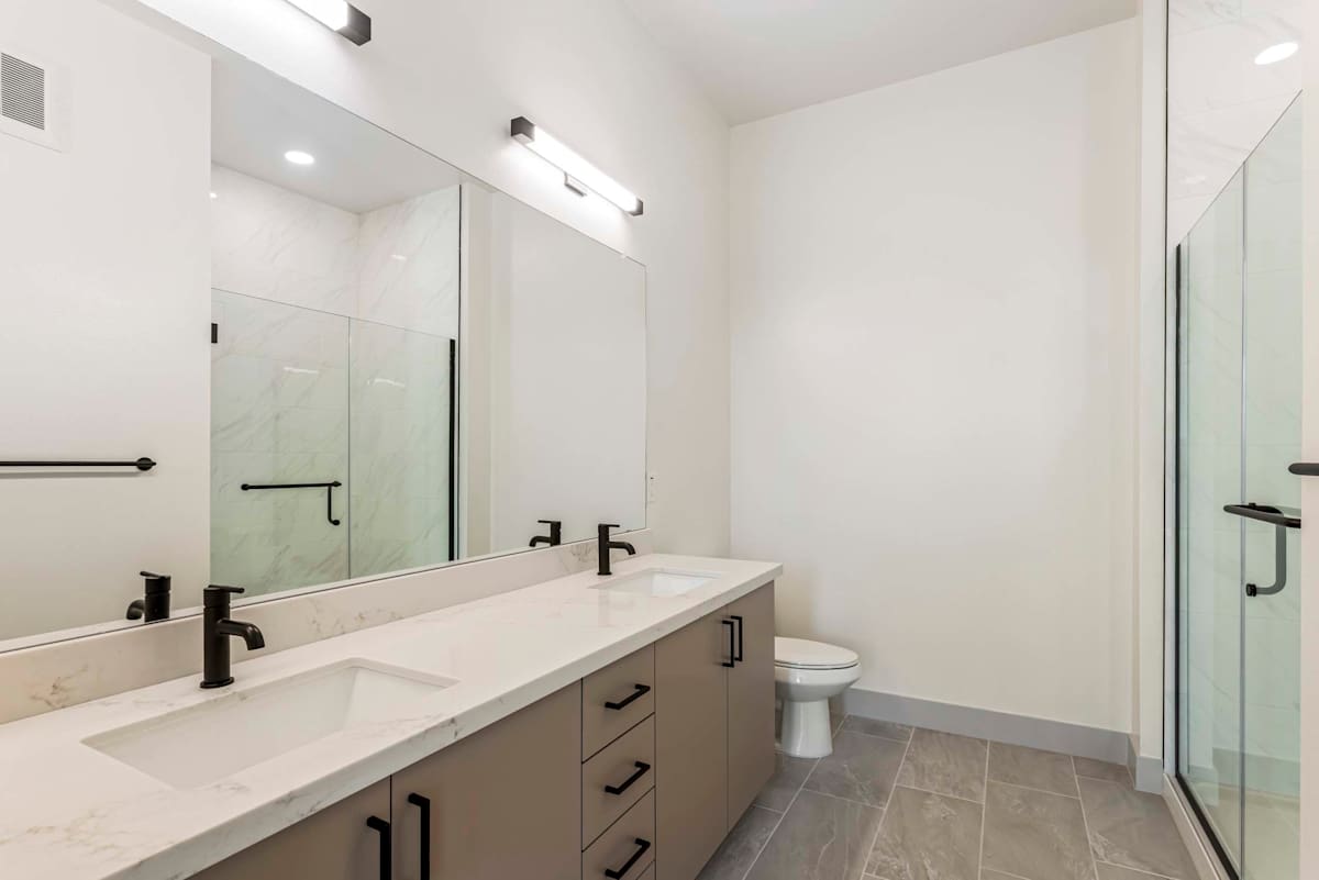 Bathroom with double vanity and walk-in shower at Elysium.