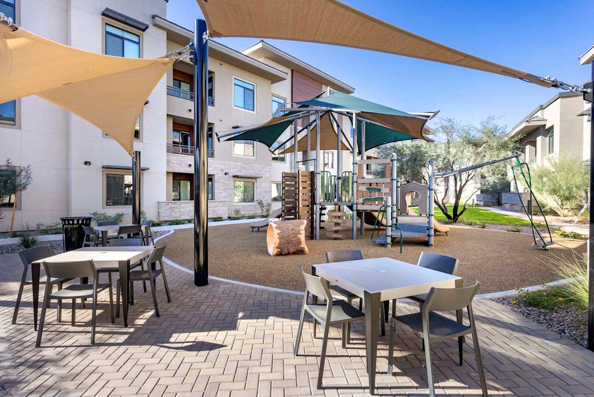 Shaded playground and picnic tables at Elysium.