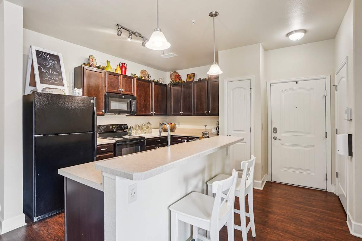 Trail Ridge at Woodland Park Apartments kitchen with black refrigerator - Woodland Park, CO
