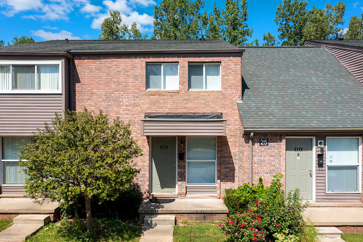 Arbor One Apartments exterior brick building with mature tree - Ypsilanti, MI