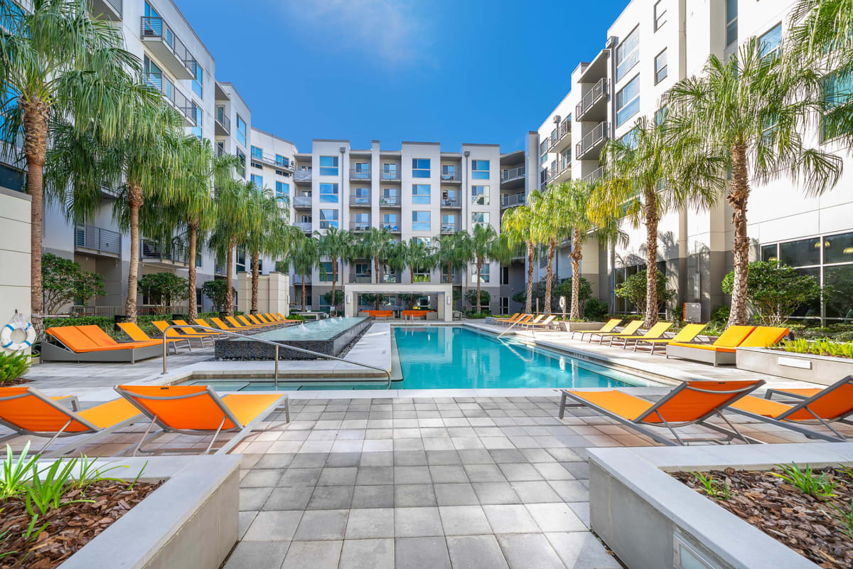 NORA Apartments pool deck with lounge chairs - Orlando, FL