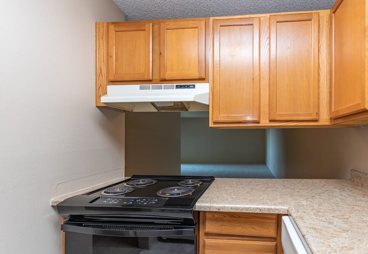 Devonshire Square apartment kitchen with black stove - Colorado Springs, CO