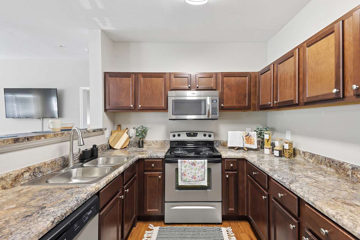 Vintage Retreat Apartments kitchen with wood cabinets and granite counters - Cleveland, TN