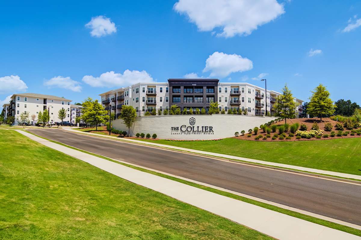 The Collier Sugar Hill Luxury Apartments exterior along tree-lined street - Sugar Hill, GA