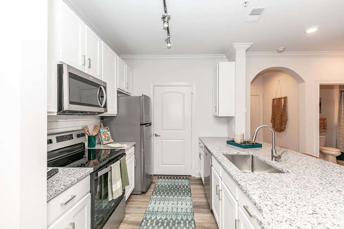The Jackson Apartments kitchen with white cabinets and granite countertops - Newnan, GA