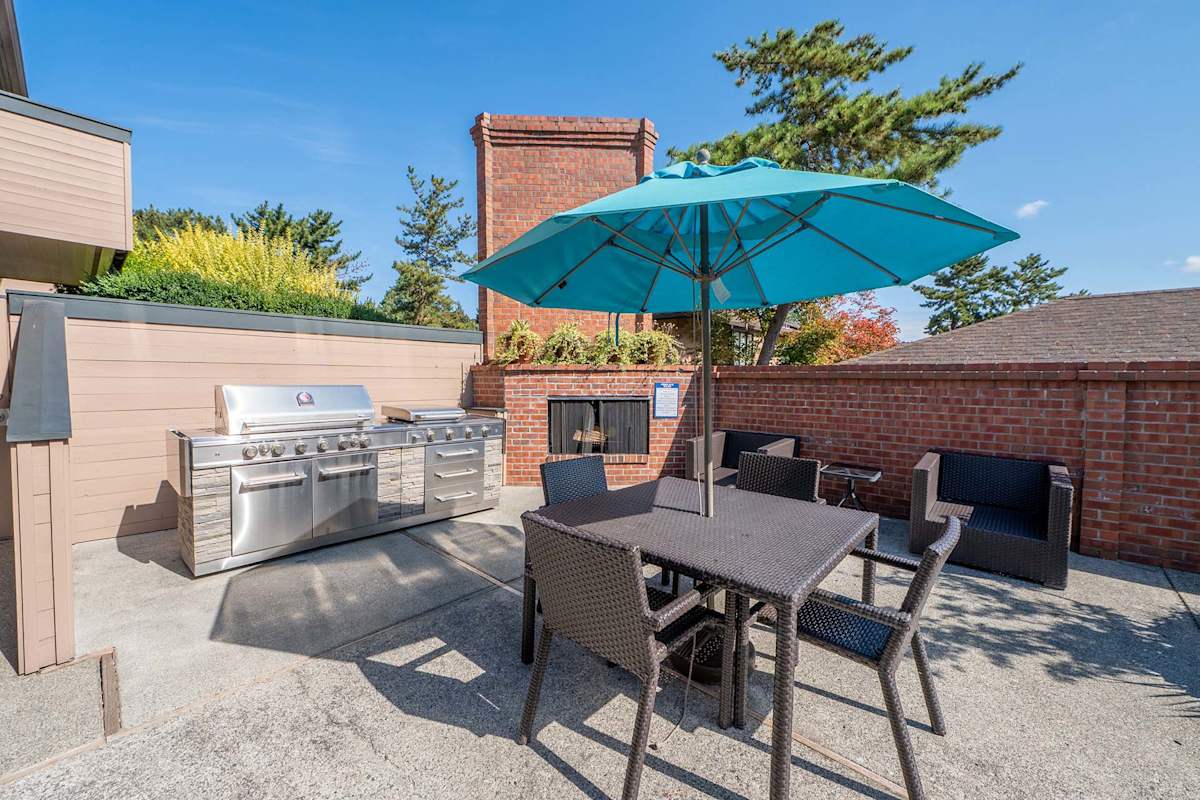 The Regent at Bellevue Way Apartments poolside grilling area with seating - Bellevue, WA