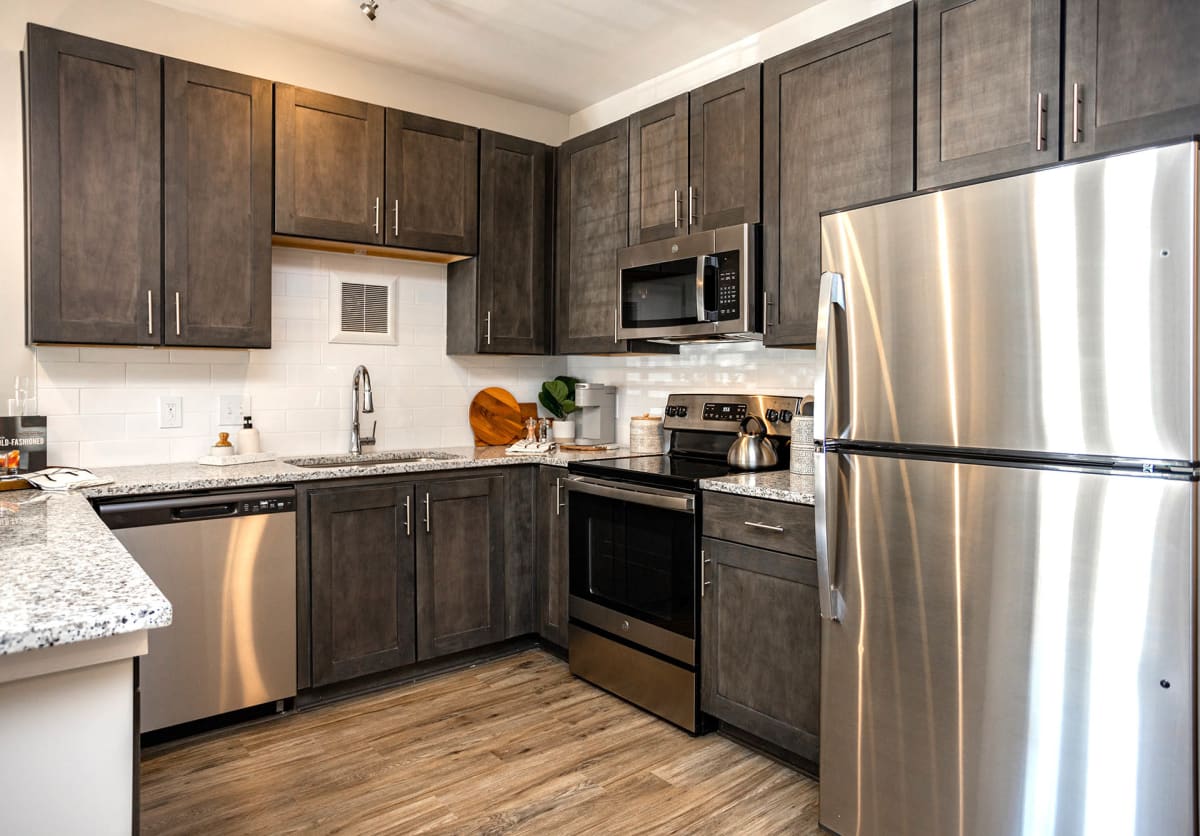 Vintage Cleveland Apartments kitchen with dark cabinets and stainless appliances - Cleveland, TN