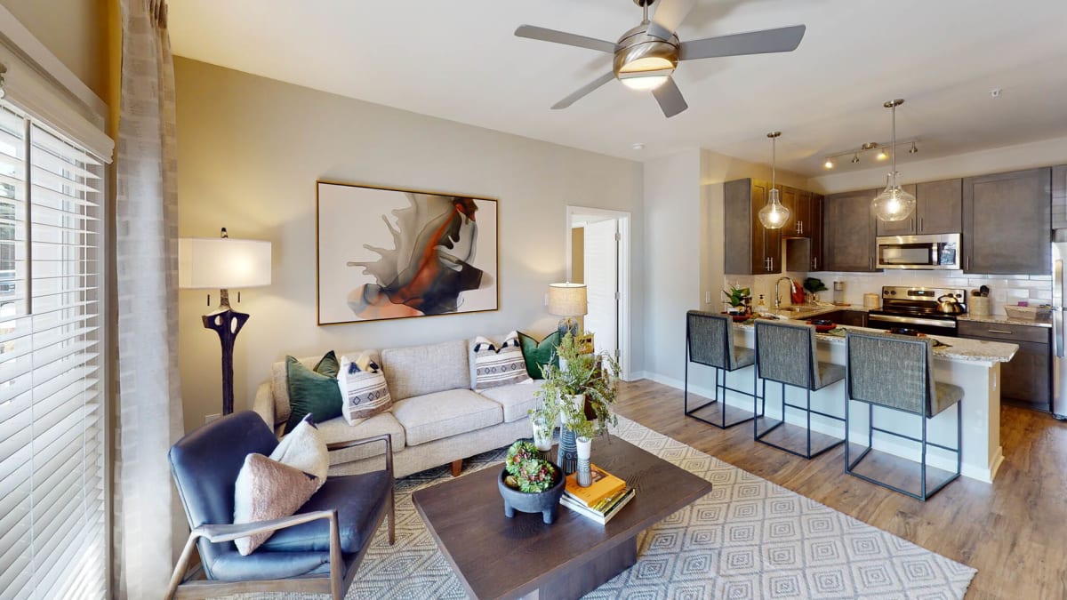 Vintage Cleveland Apartments living room with ceiling fan and kitchen - Cleveland, TN