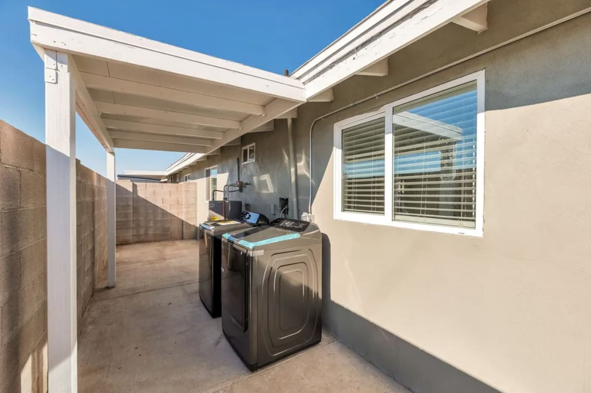Washer and dryer in a covered outdoor utility area at Desert Green.