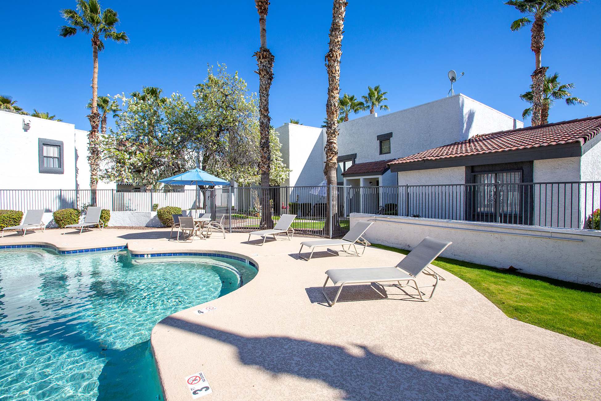 Pool and poolside area at Townhomes on the Park Apartment Homes.
