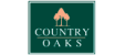 Country Oaks property logo with green background, white lettering, and light orange trees at Country Oaks Apartments in Clearfield, Utah