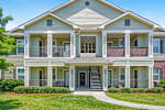A two-story house with a front porch and a balcony on the second floor.