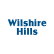 a blue logo with the words whispering hills on a white background