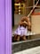 A dog wearing a purple coat is sitting on a step.