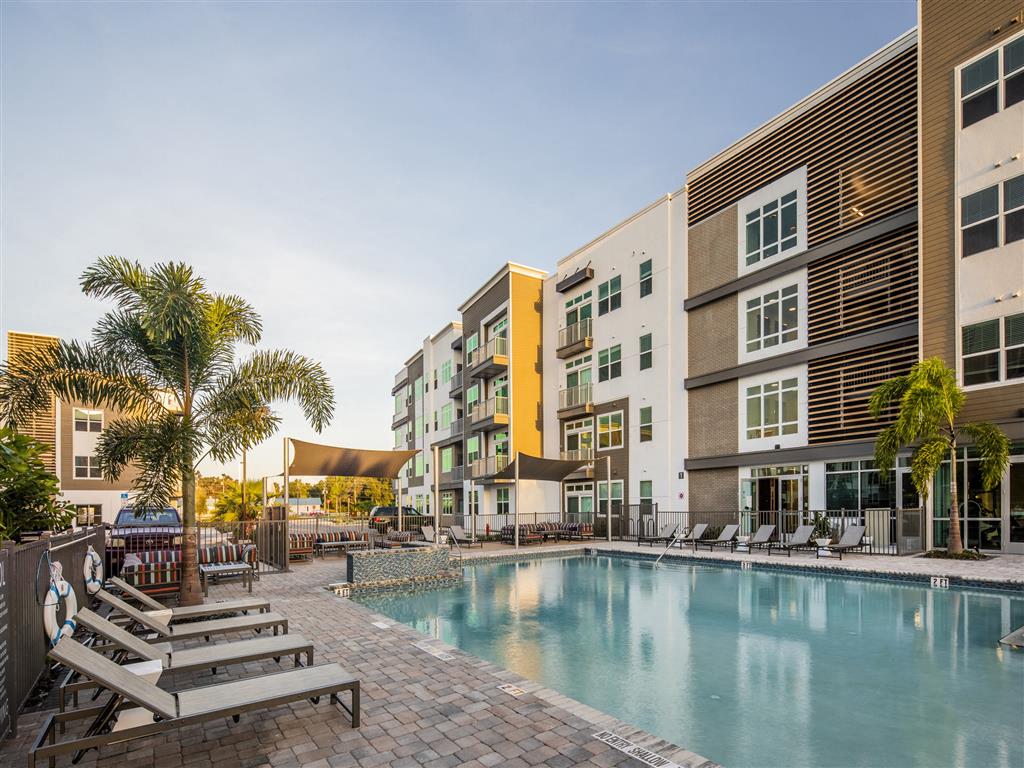 Resort-style swimming pool and apartment buildings at 10X Tarpon Springs