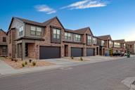 A row of houses with garages and driveways.