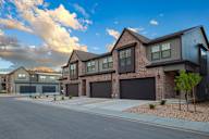 A row of modern houses with garages and driveways.