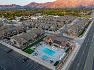 A large residential complex with a swimming pool and a mountain in the background.