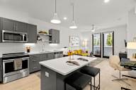 Dog-Friendly Apartments in Sacramento, CA - The Eisley - Kitchen with a Granite-Style Island, Hanging Light Fixtures, and Stainless-Steel Appliances