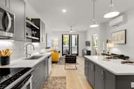 a kitchen with white counter tops and gray cabinets