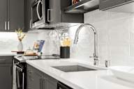 a black and white kitchen with a sink and a faucet