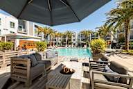 a swimming pool with lounge chairs and a table with a fire pit