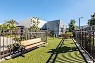 a small grassy area with benches and a fence