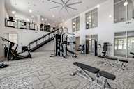 a gym with exercise equipment and a staircase