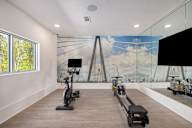a gym with weights and a mural of a bridge on the wall