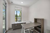 an office space with a desk and a chair and a window