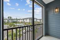 a balcony with a view of a building and palm trees