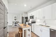 a kitchen with white cabinets and a floating island