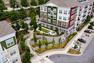 Apartment complex with a green lawn and trees.