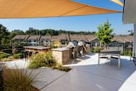 A sunny day at a residential area with houses and a patio.