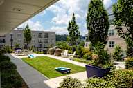 A sunny day at a residential complex with a pool and a playground.