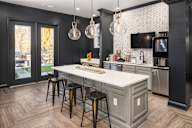 A kitchen with a white countertop and a black and white tiled backsplash.