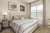 A bedroom with a bed, nightstand, and two framed pictures on the wall.