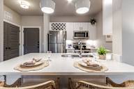 A modern kitchen with a dining table set for two.