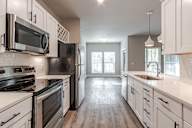 A kitchen with black appliances and white cabinets.
