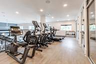 A gym with treadmills and elliptical machines.