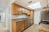 A kitchen with wooden cabinets and a granite countertop at The Viridian, Scottsdale, Arizona