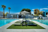 a pool with lounge chairs and umbrellas next to a building at Connect on Missouri, Arizona, 85015