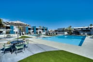 a swimming pool with tables and umbrellas at the clubhouse of a apartments complex at Connect on Missouri, Phoenix, 85015