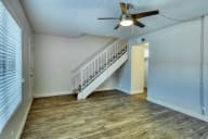 a living room with a staircase and a ceiling fan at Connect on Missouri, Phoenix