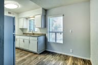 an empty kitchen with white cabinets and a sink and a window at Connect on Missouri, Phoenix Arizona