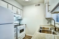 an empty kitchen with white appliances and a sink at Connect on Missouri, Phoenix, AZ 85015