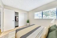 A bedroom with a bed, a plant, and a wardrobe at Connect on Missour Apartments, Phoenix, Arizona